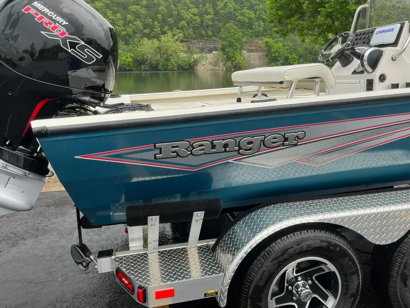 Slide: The Image of 2024 Ranger RB200 boat with Mercury engine on a trailer by a lake. - 2