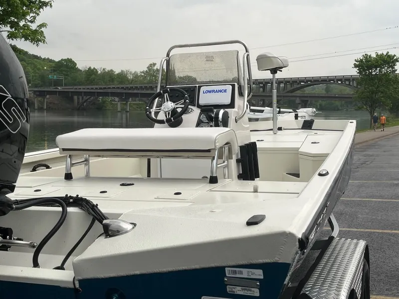 Slide: The Image of 2024 Ranger RB200 boat docked near a river with bridge in background. - 6