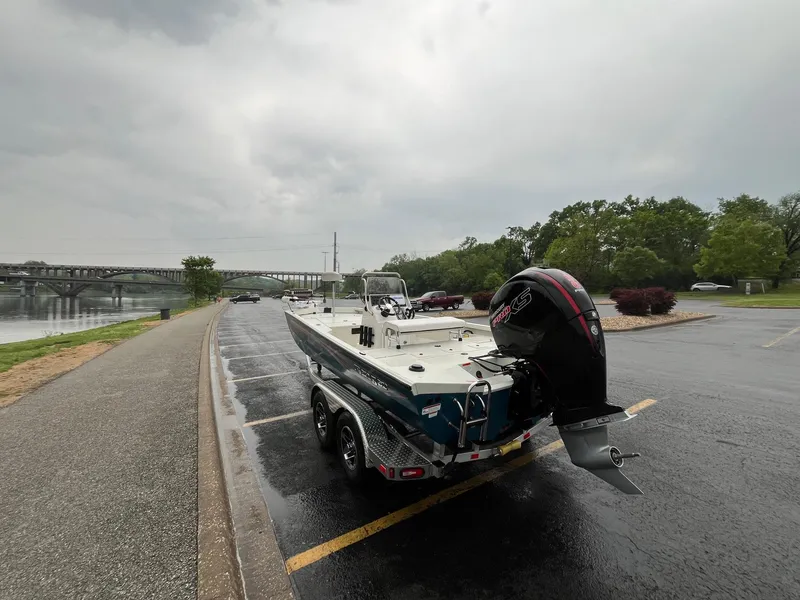 Slide: The Image of 2024 Ranger RB200 boat on trailer near river, overcast sky, bridge in background. - 8