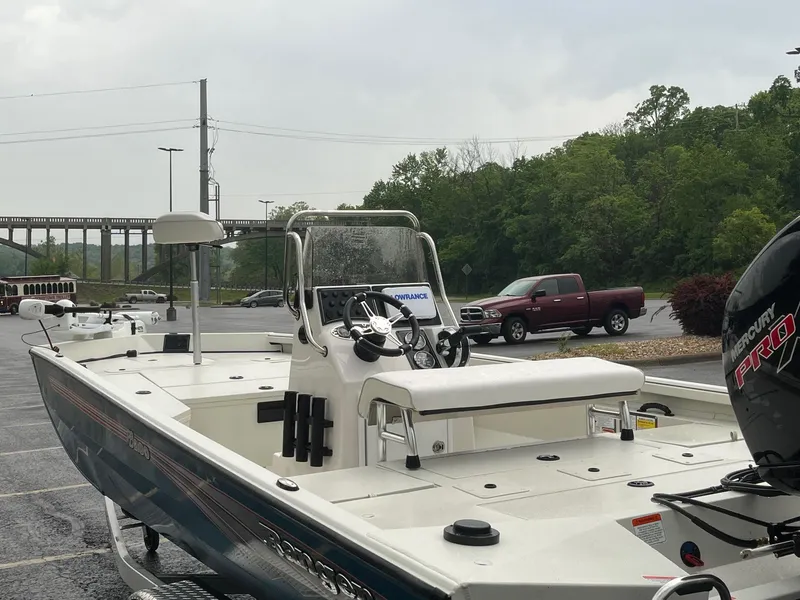 Slide: The Image of 2024 Ranger RB200 boat parked outdoors near trees and a bridge. - 9