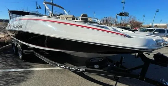 Slide: The Image of 2024 Tahoe 2150 boat on trailer in parking lot, sunny day. - 2