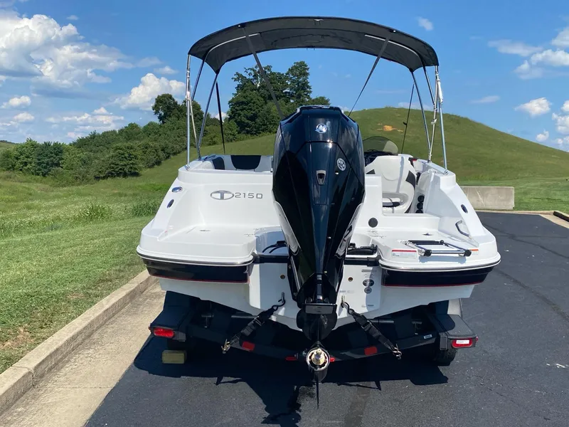 Slide: The Image of 2024 Tahoe 2150 boat with outboard motor on trailer, parked on sunny day. - 4
