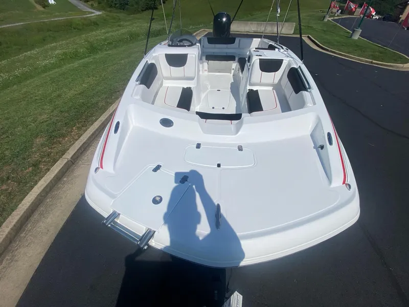 Slide: The Image of 2024 Tahoe 2150 boat, white interior, parked on a paved road. - 9