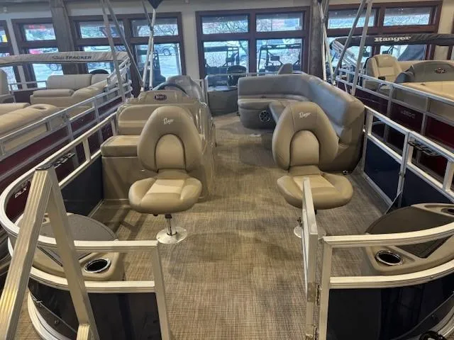 Slide: The Image of 2024 Ranger Reata 200F pontoon boat interior with beige seating and spacious layout. - 2