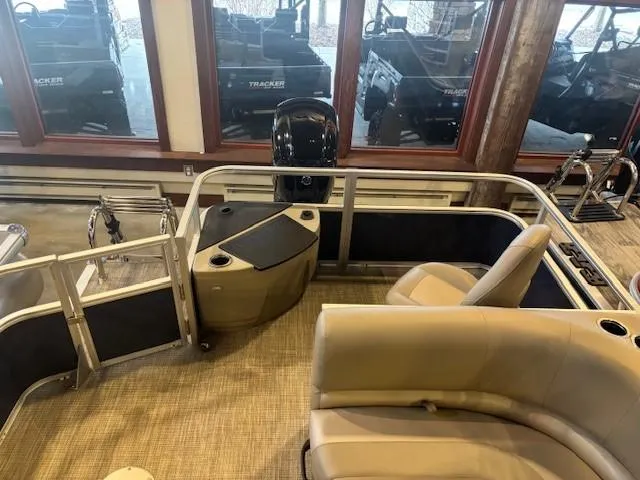 Slide: The Image of 2024 Ranger Reata 200F pontoon boat interior with seating and motor, displayed indoors. - 4