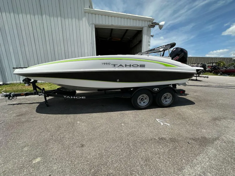 Slide: The Image of 2024 Tahoe 1950 boat on trailer, parked outside a warehouse. - 4