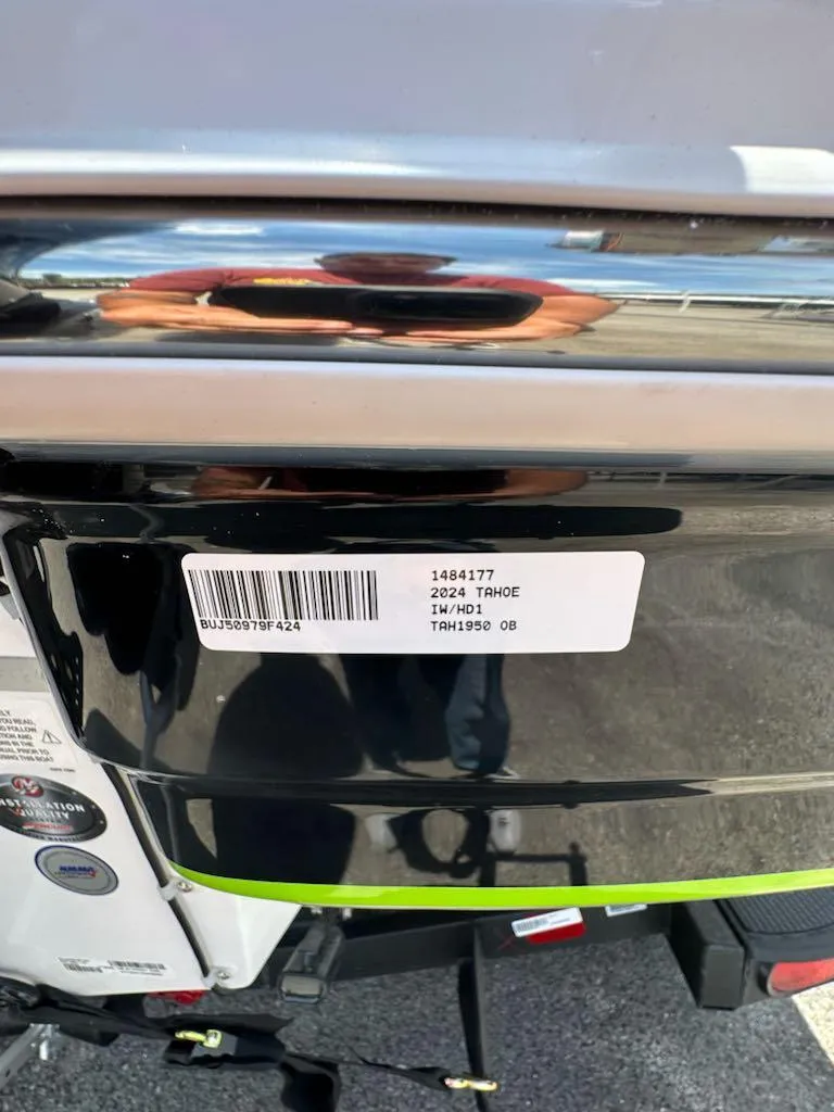 Slide: The Image of 2024 Tahoe 1950 boat with barcode sticker on black and silver surface. - 9