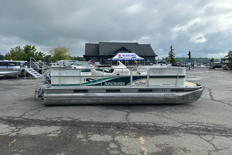 The Image of 1999 Suncruiser Trinidad 200 pontoon boat parked in a marina lot. - 0