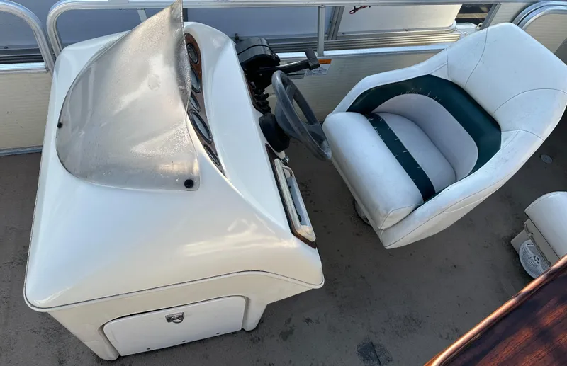 Slide: The Image of 1999 Suncruiser Trinidad 200 boat interior with steering console and cushioned seat. - 10