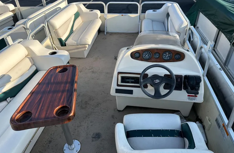 Slide: The Image of 1999 Suncruiser Trinidad 200 pontoon boat interior with seating and steering console. - 11
