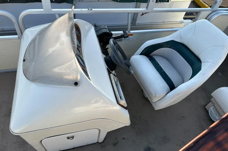 Slide: The Image of Captain's chair and helm of 1999 Suncruiser Trinidad 200 boat. - 12