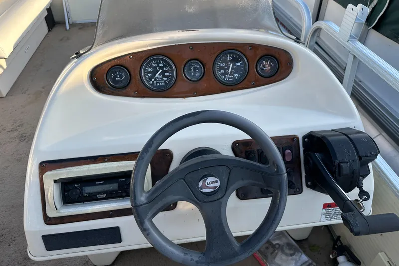 Slide: The Image of 1999 Suncruiser Trinidad 200 boat dashboard with steering wheel and control panel. - 13