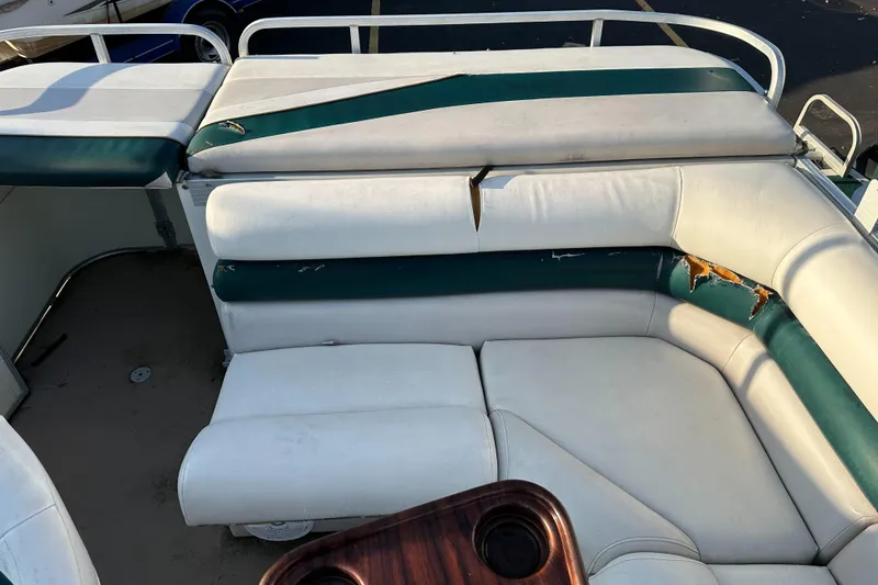 Slide: The Image of 1999 Suncruiser Trinidad 200 boat interior with worn white and green seating. - 14