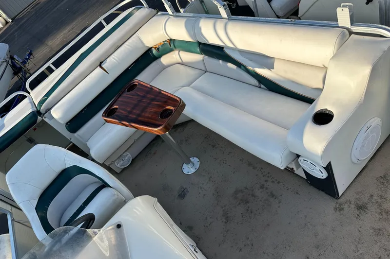 Slide: The Image of 1999 Suncruiser Trinidad 200 boat interior with white seating and wooden table. - 9