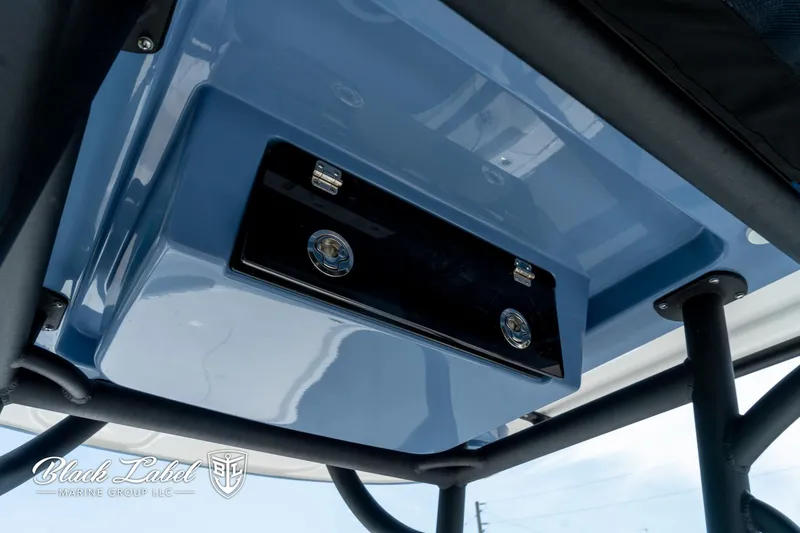 Slide: The Image of 2025 Caymas 281 HB boat console detail with blue finish and storage compartment. - 17