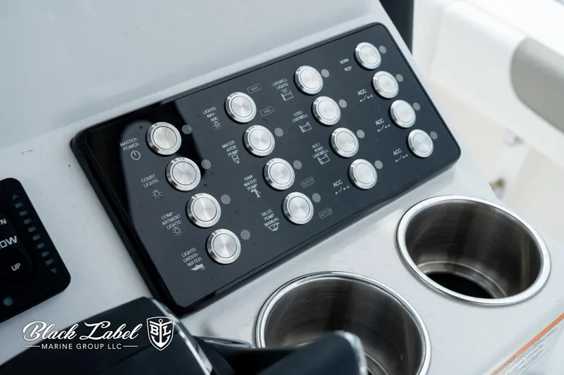 Slide: The Image of Control panel of 2025 Caymas 281 HB boat with cup holders, Black Label Marine Group logo. - 20