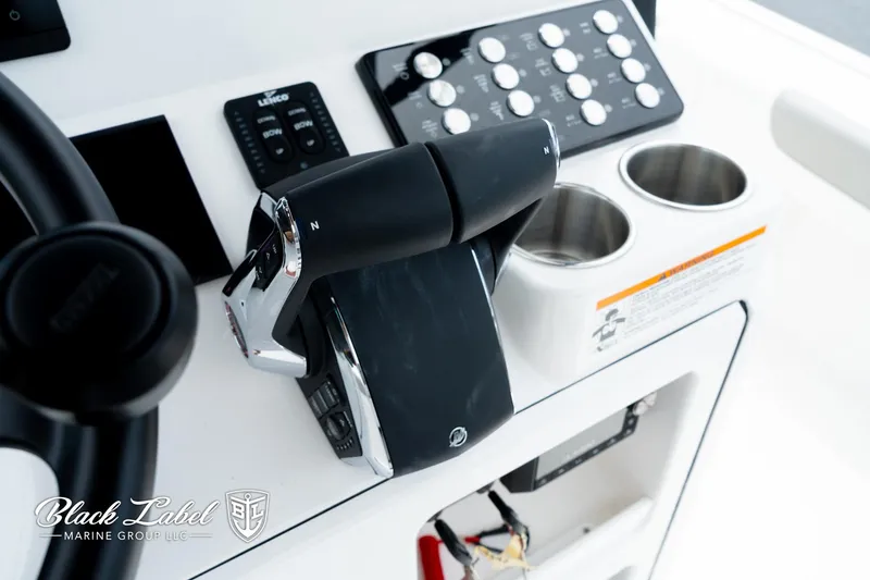 Slide: The Image of Control panel of 2025 Caymas 281 HB boat with throttle and cup holders. - 22
