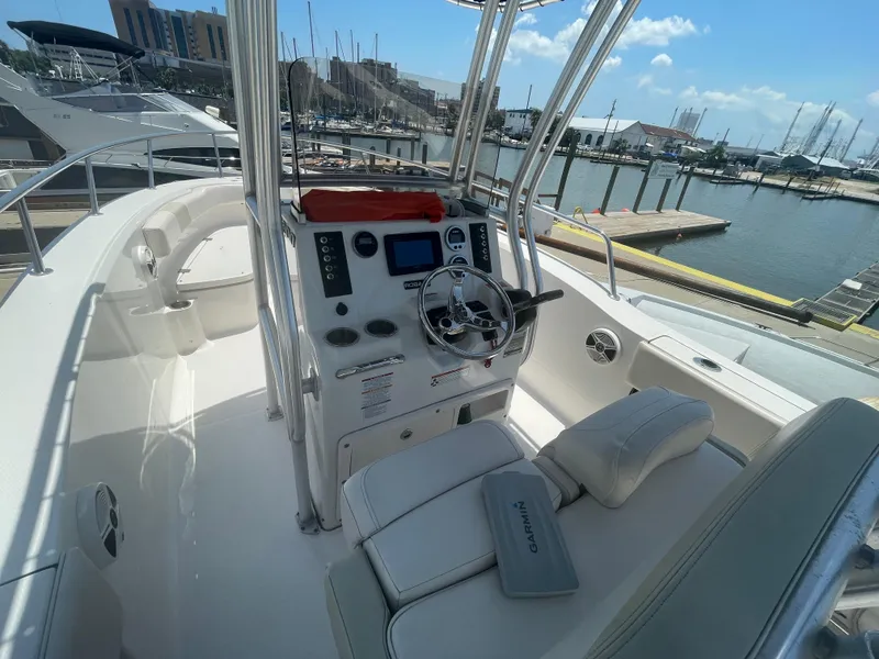 Slide: The Image of 2016 Robalo R200 Center Console boat interior at marina, featuring steering console and seating. - 19
