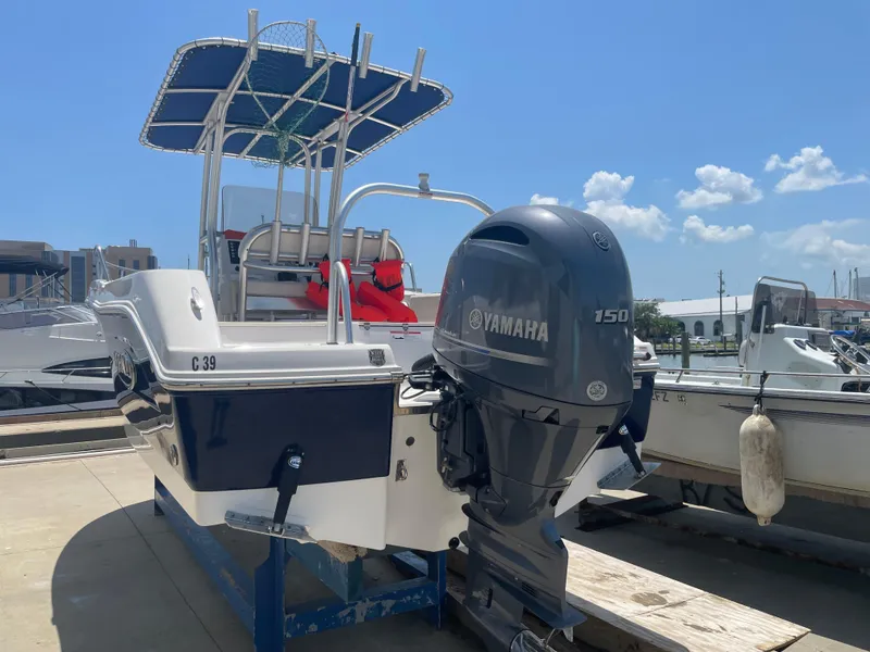 Slide: The Image of 2016 Robalo R200 Center Console boat with Yamaha 150 engine, docked under clear skies. - 4