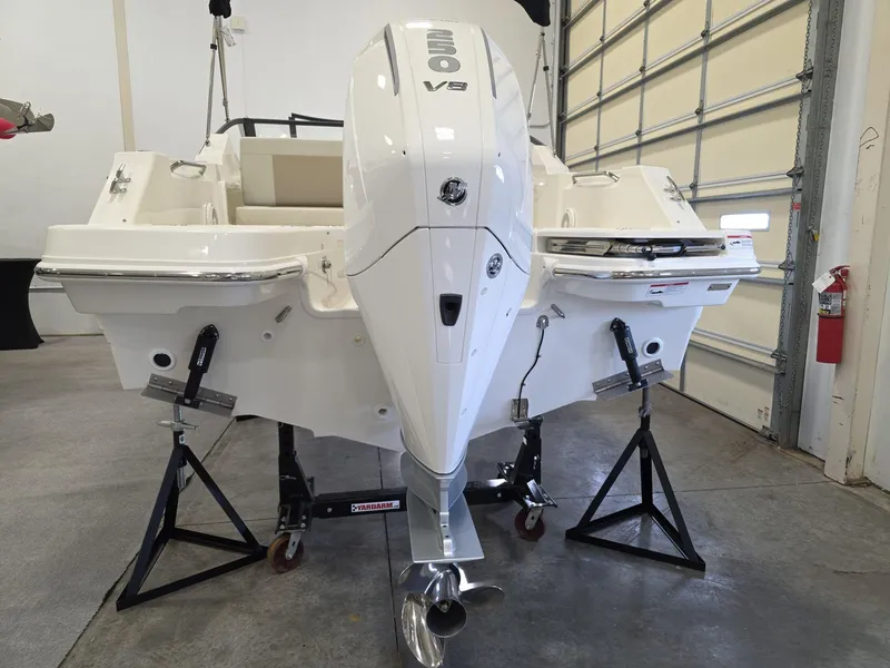 Slide: The Image of 2025 Boston Whaler 210 Vantage boat in garage, showcasing powerful outboard motor. - 12