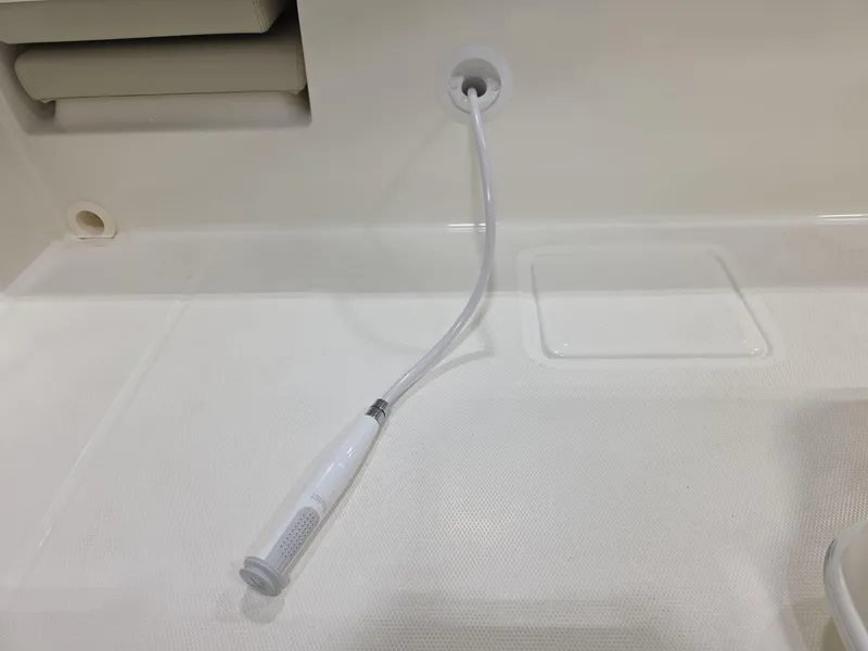 Slide: The Image of 2025 Boston Whaler 210 Vantage boat interior with a white hose attachment. - 13