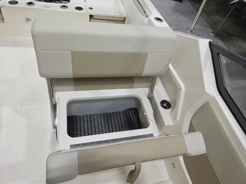 Slide: The Image of 2025 Boston Whaler 210 Vantage boat interior with beige seating and storage compartment. - 14
