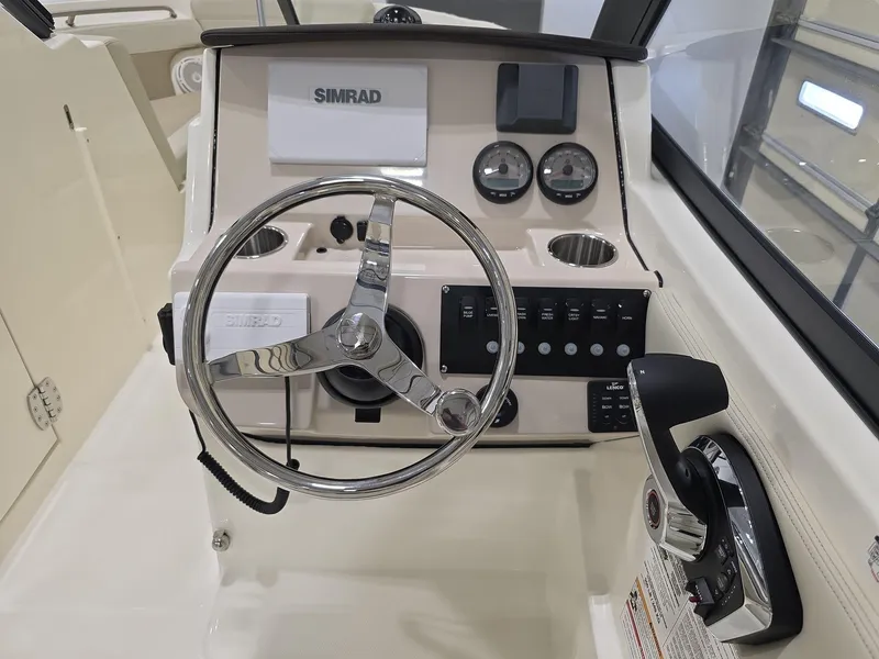 Slide: The Image of 2025 Boston Whaler 210 Vantage dashboard with steering wheel and controls. - 7