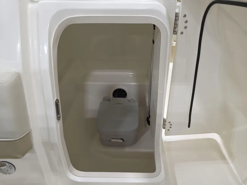 Slide: The Image of 2025 Boston Whaler 210 Vantage boat interior with compact marine toilet. - 8