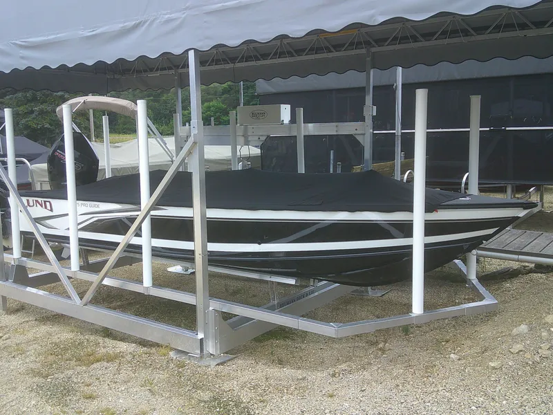 The Image of 2024 Lund 2075 Pro Guide boat on lift, covered and docked. - 1