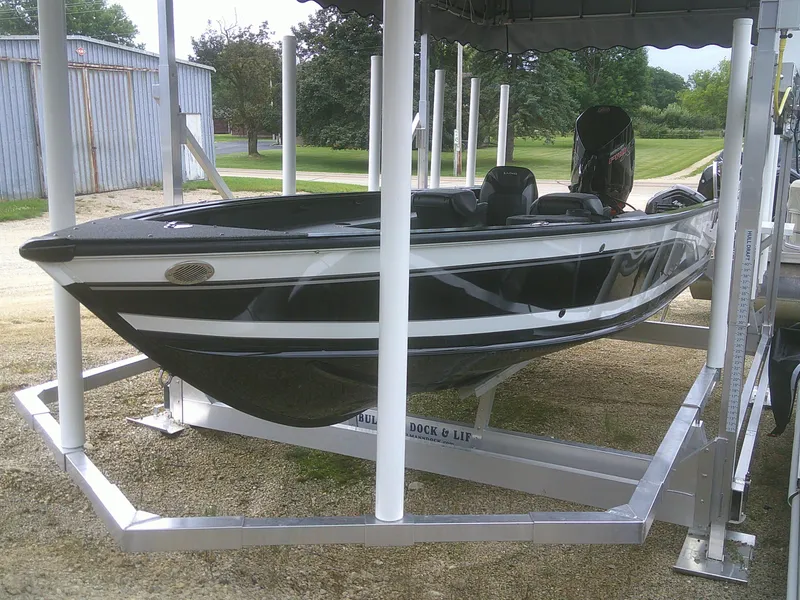 Slide: The Image of 2024 Lund 2075 Pro Guide boat on lift, black and white design. - 12