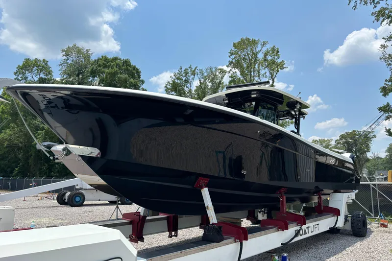 Slide: The Image of 2017 HCB Speciale boat cruising on a calm river with lush greenery. - 1