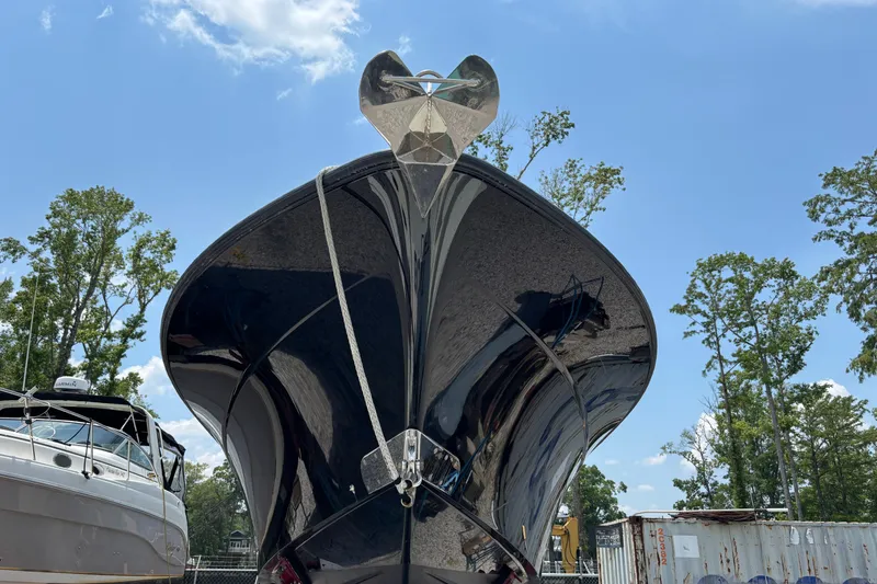 Slide: The Image of 2017 HCB Speciale boat on calm water, surrounded by lush greenery and docked vessels. - 2
