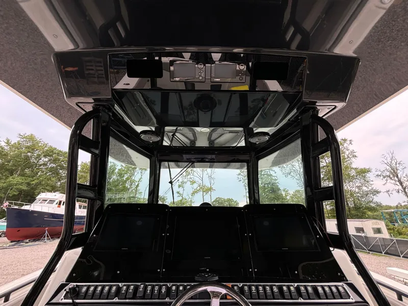 Slide: The Image of 2017 HCB Speciale boat interior with gray seating and deck, docked near other boats. - 25