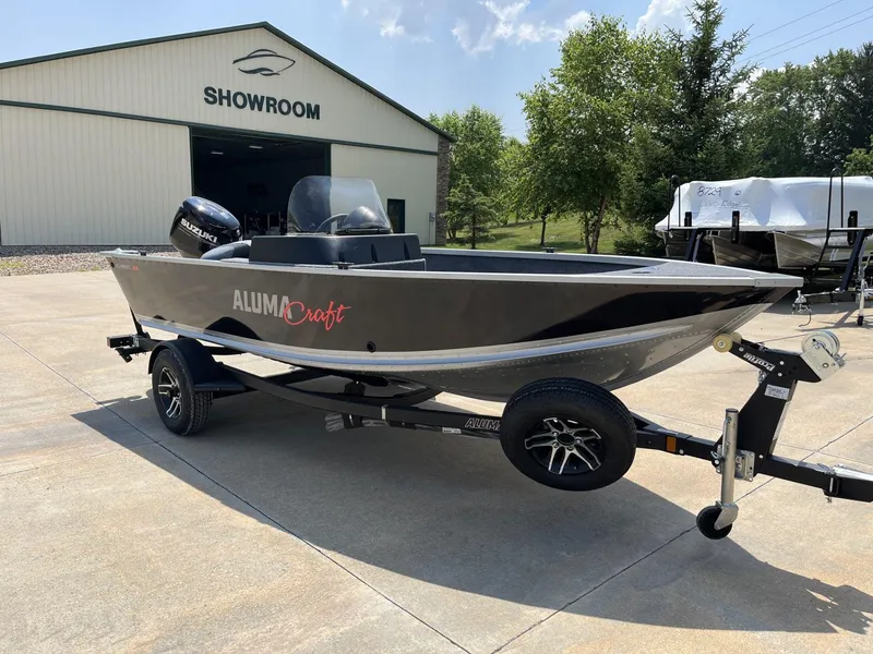 Slide: The Image of 2024 Alumacraft Classic 165 CS boat on trailer outside showroom. - 1