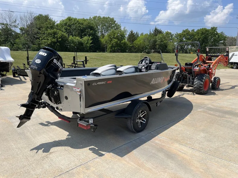 Slide: The Image of 2024 Alumacraft Classic 165 CS boat on trailer, parked outdoors. - 4