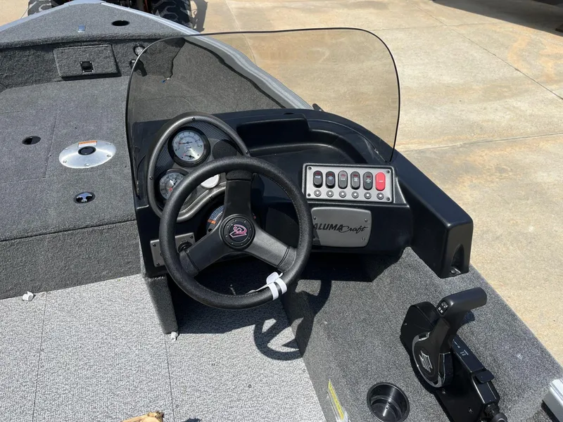 Slide: The Image of 2024 Alumacraft Classic 165 CS boat dashboard with steering wheel and control panel. - 6