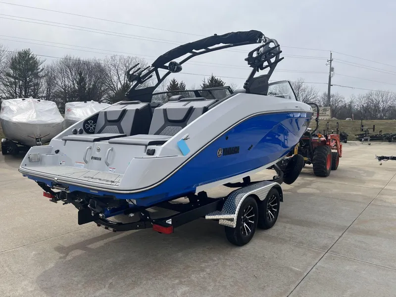 Slide: The Image of 2024 Yamaha Boats 222XD on trailer, blue and white design, parked outdoors. - 4
