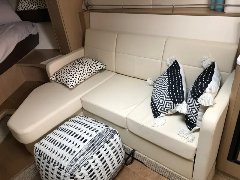 Slide: The Image of 2018 Sea Ray 350 Sundancer Coupe interior with beige sofa and patterned cushions. - 15