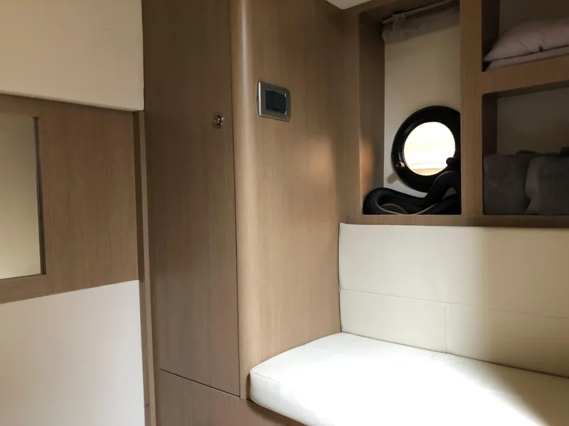 Slide: The Image of Interior of 2018 Sea Ray 350 Sundancer Coupe with wood paneling and porthole window. - 20