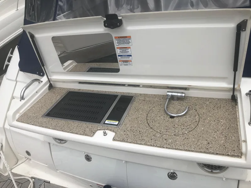 Slide: The Image of Outdoor kitchenette on 2018 Sea Ray 350 Sundancer Coupe yacht, featuring grill and sink. - 24