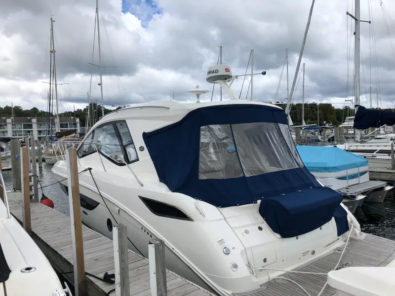 Slide: The Image of 2018 Sea Ray 350 Sundancer Coupe docked at marina under cloudy sky. - 27