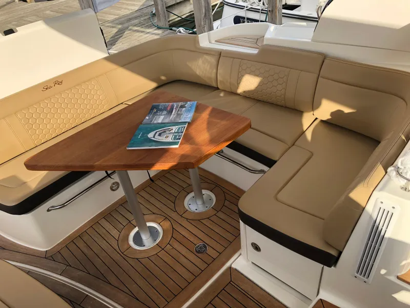 Slide: The Image of Luxurious seating area on 2018 Sea Ray 350 Sundancer Coupe with wooden table and magazine. - 3