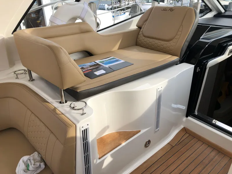 Slide: The Image of 2018 Sea Ray 350 Sundancer Coupe interior with tan leather seating and wood flooring. - 4