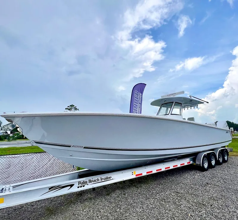 Slide: The Image of 2025 Jupiter 380LS boat on trailer under cloudy sky. - 1