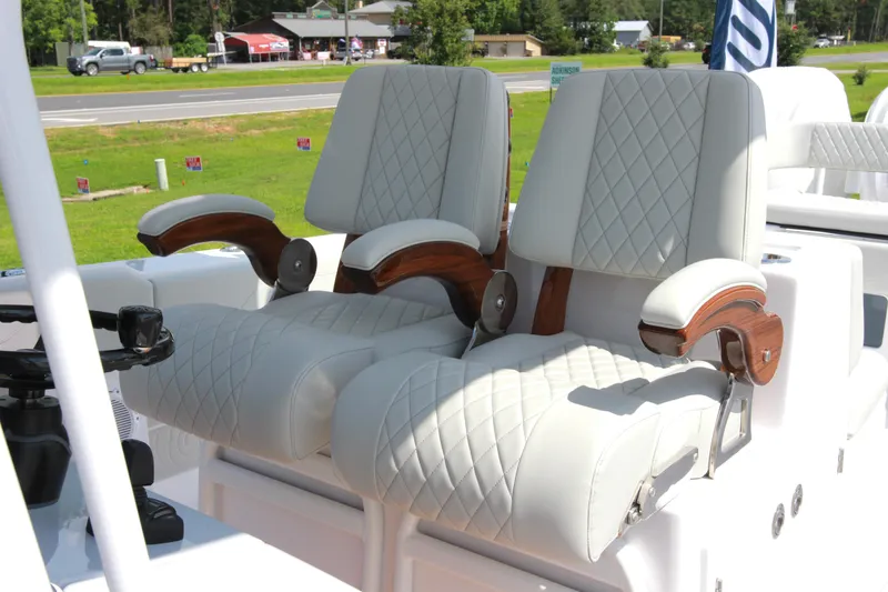 Slide: The Image of Luxury seating on 2025 Jupiter 380LS boat with quilted upholstery and wooden armrests. - 19