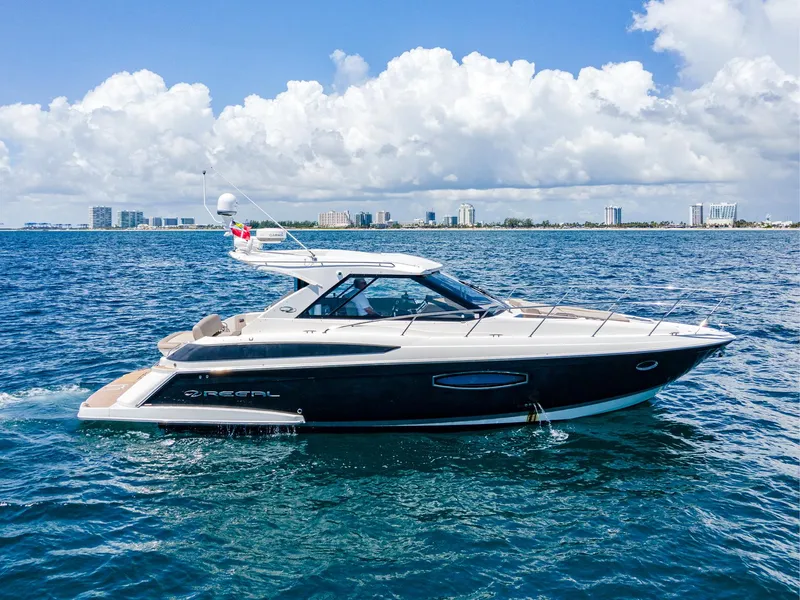 Slide: The Image of 2015 Regal 42 Sport Coupe yacht cruising on open water under a clear sky. - 2
