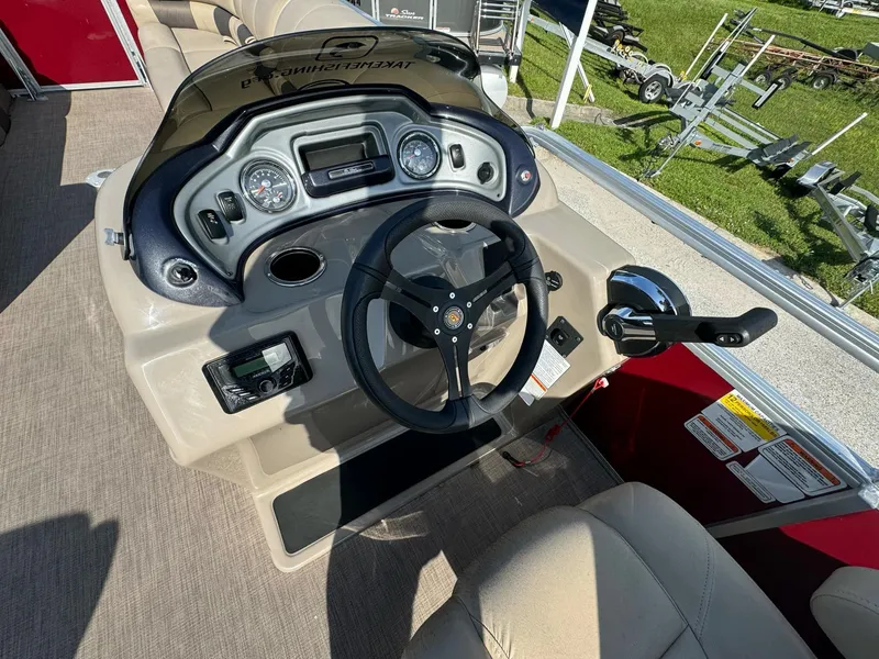 Slide: The Image of 2023 Sun Tracker Party Barge 24 DLX dashboard with steering wheel and controls. - 7