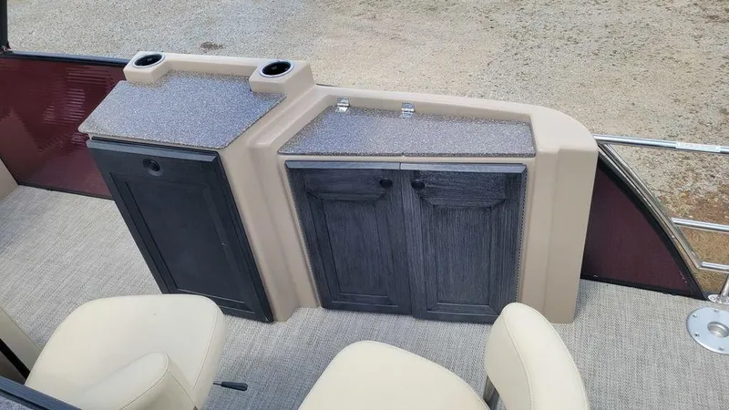 Slide: The Image of Interior of 2023 AquaPatio 275 CBE iMPACT boat with storage cabinets and seating. - 11