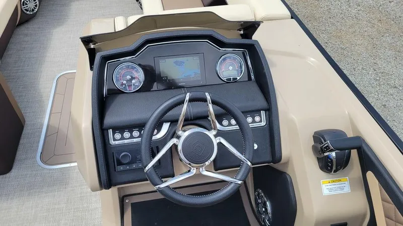 Slide: The Image of 2023 AquaPatio 275 CBE iMPACT boat dashboard with steering wheel and control panel. - 7