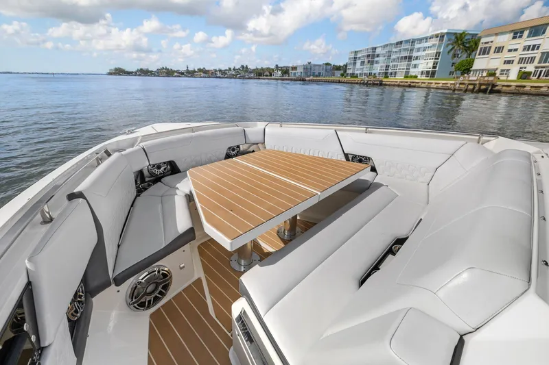Slide: The Image of 2022 Formula 500 Super Sport Crossover boat interior with seating and table on a sunny day. - 25